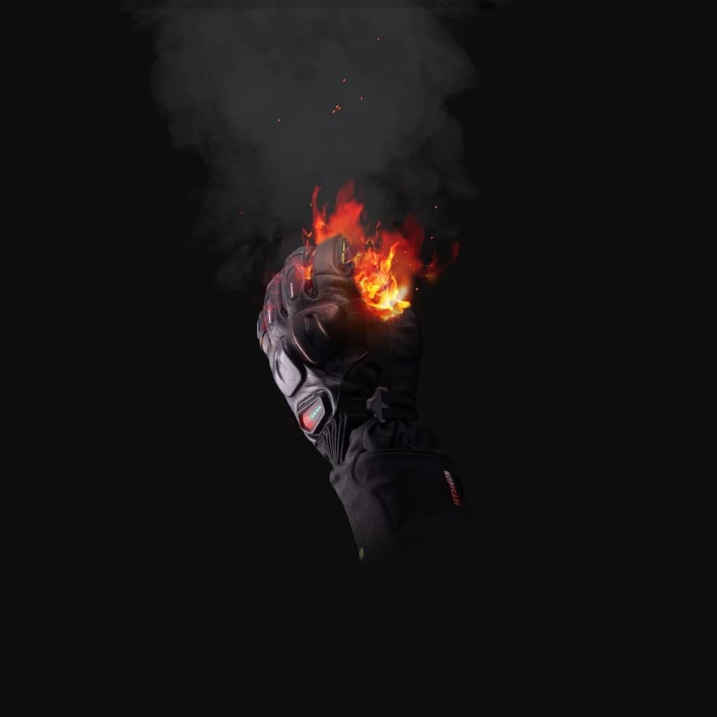 Ixon heated motorcycle glove raised in a fist with flames, symbolising the active warmth technology for winter commuting
