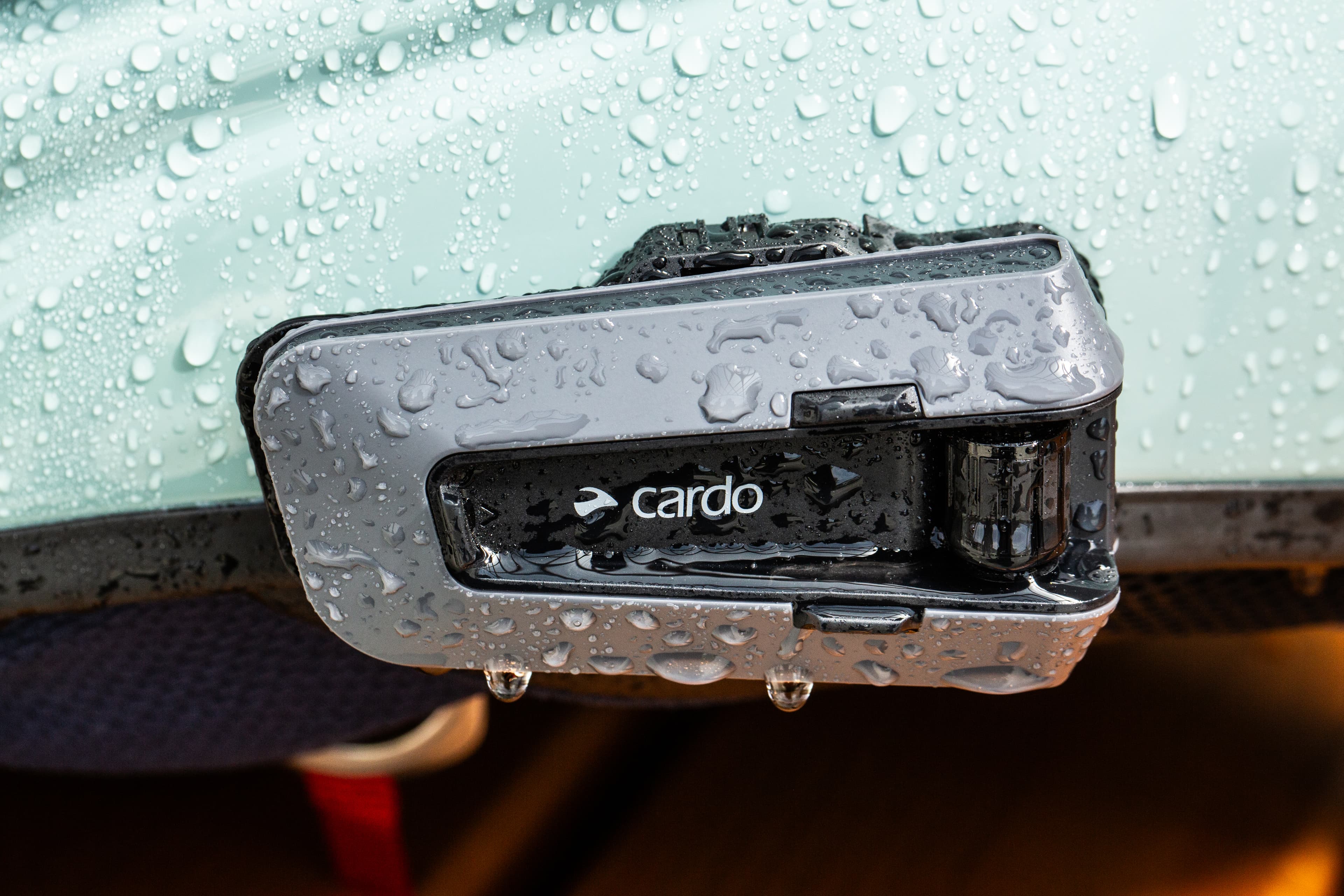Cardo Packtalk motorcycle Bluetooth communication system mounted on helmet for rider-to-rider intercom